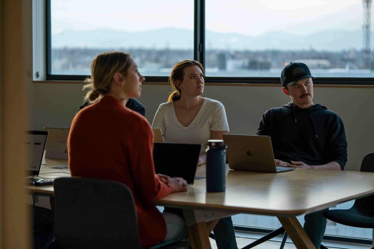 Marketing team sitting at table talking about strategy.