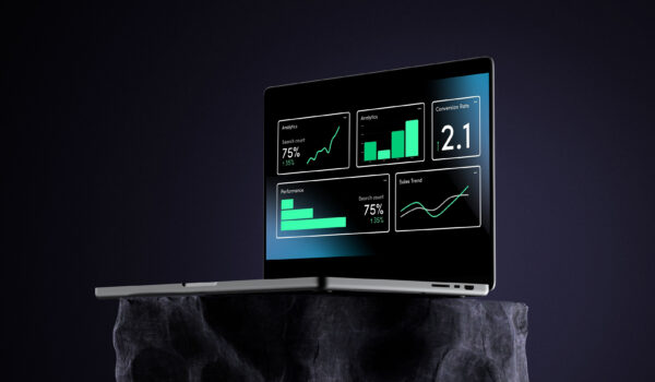 Silver laptop displaying website analytics dashboards, including graphs, charts, and a 2.1 conversion rate metric, placed on a dark stone pedestal against a black background, symbolizing digital performance and KPIs for websites.