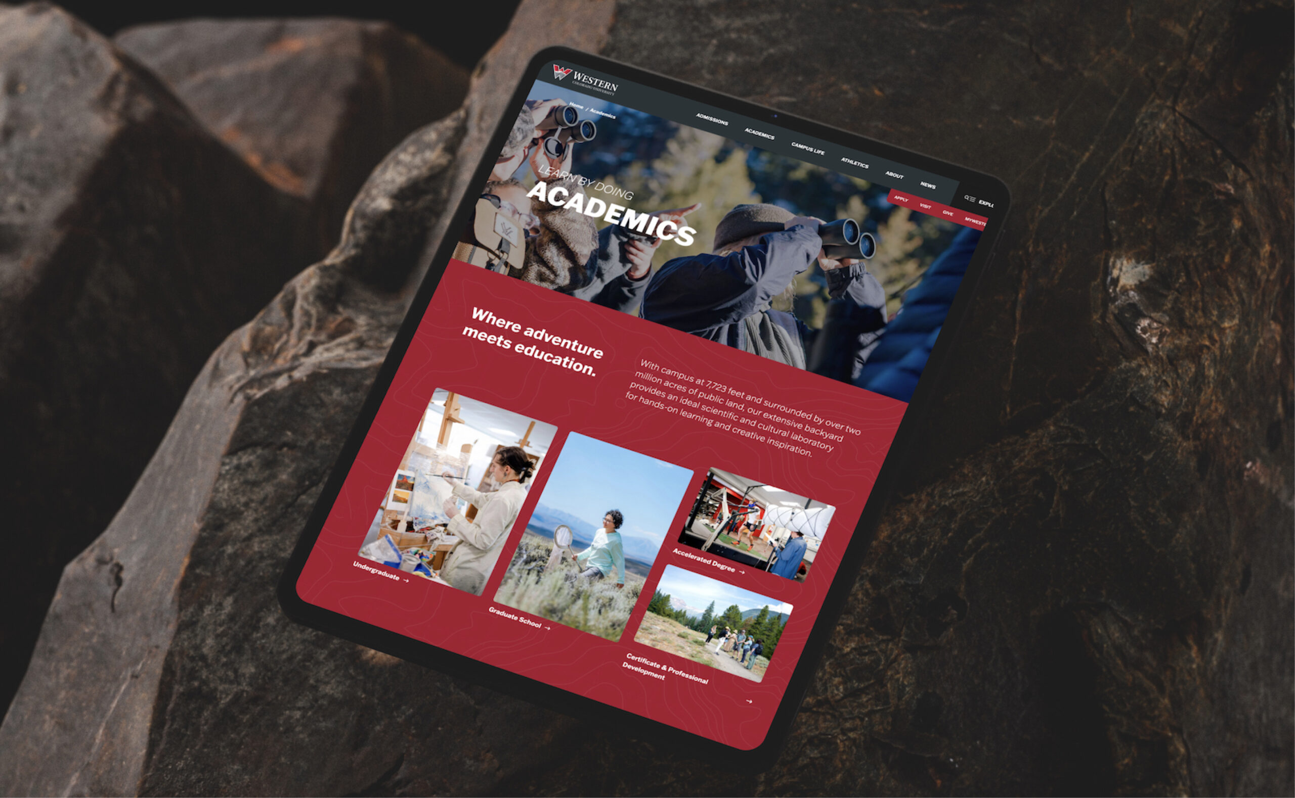 Tablet displaying website interface on rocky surface