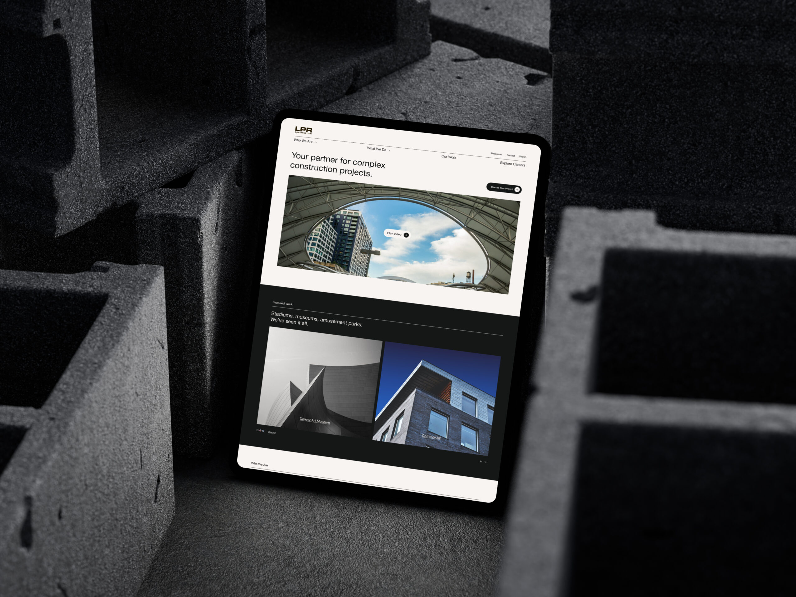 iPad Pro mockup with modern construction website placed on textured concrete blocks