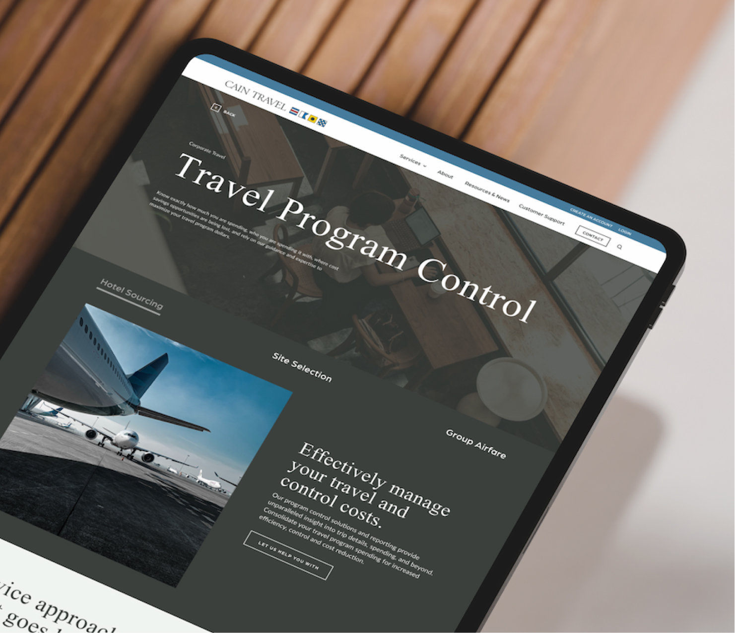 Tablet showing travel website design on wooden surface