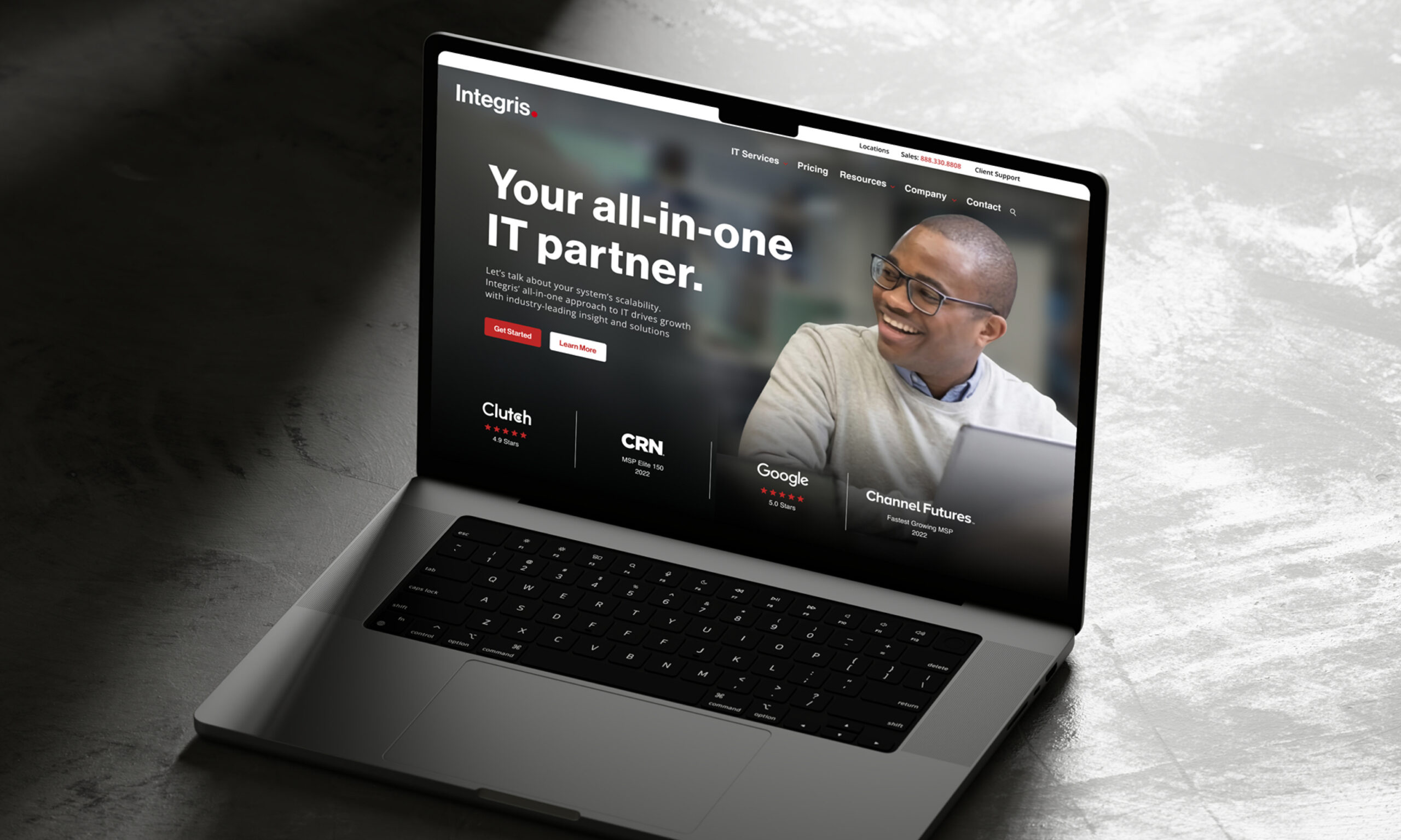 Laptop displaying marketing website with dark theme