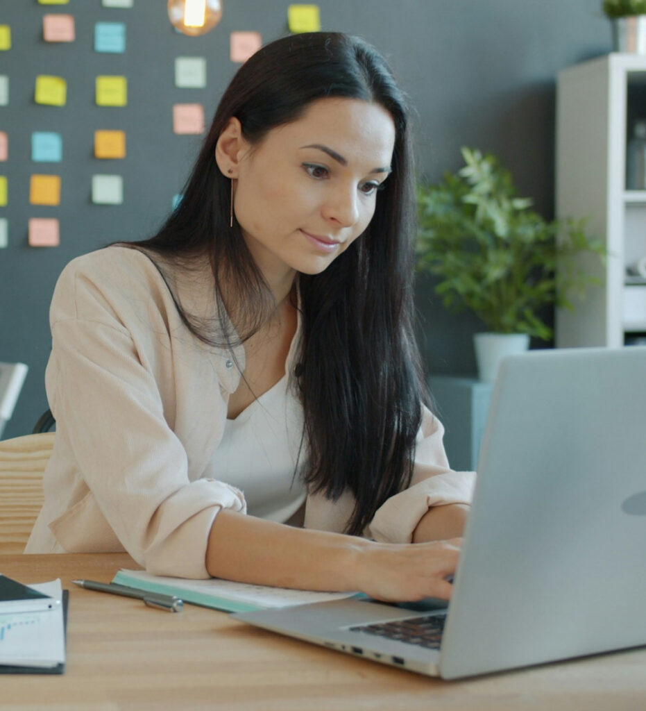 Woman working on laptop in office setting