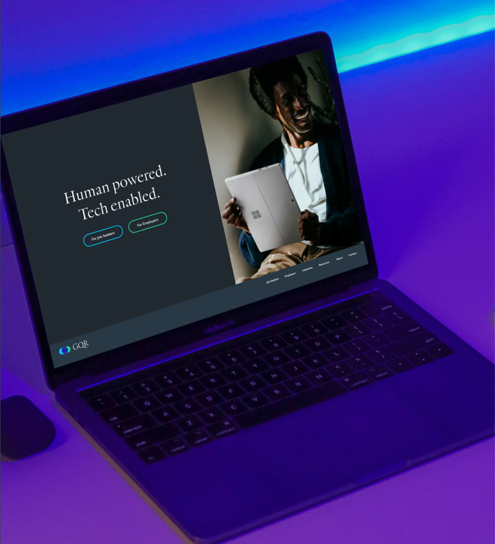 Laptop displaying website homepage with gradient background