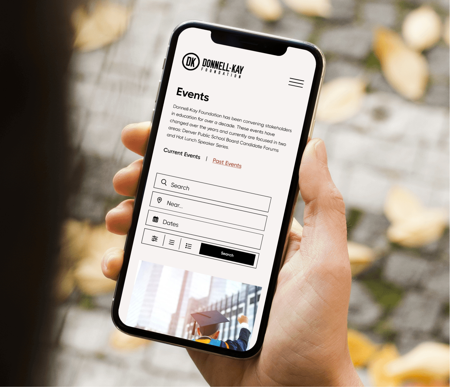 Mobile phone displaying website interface in hand