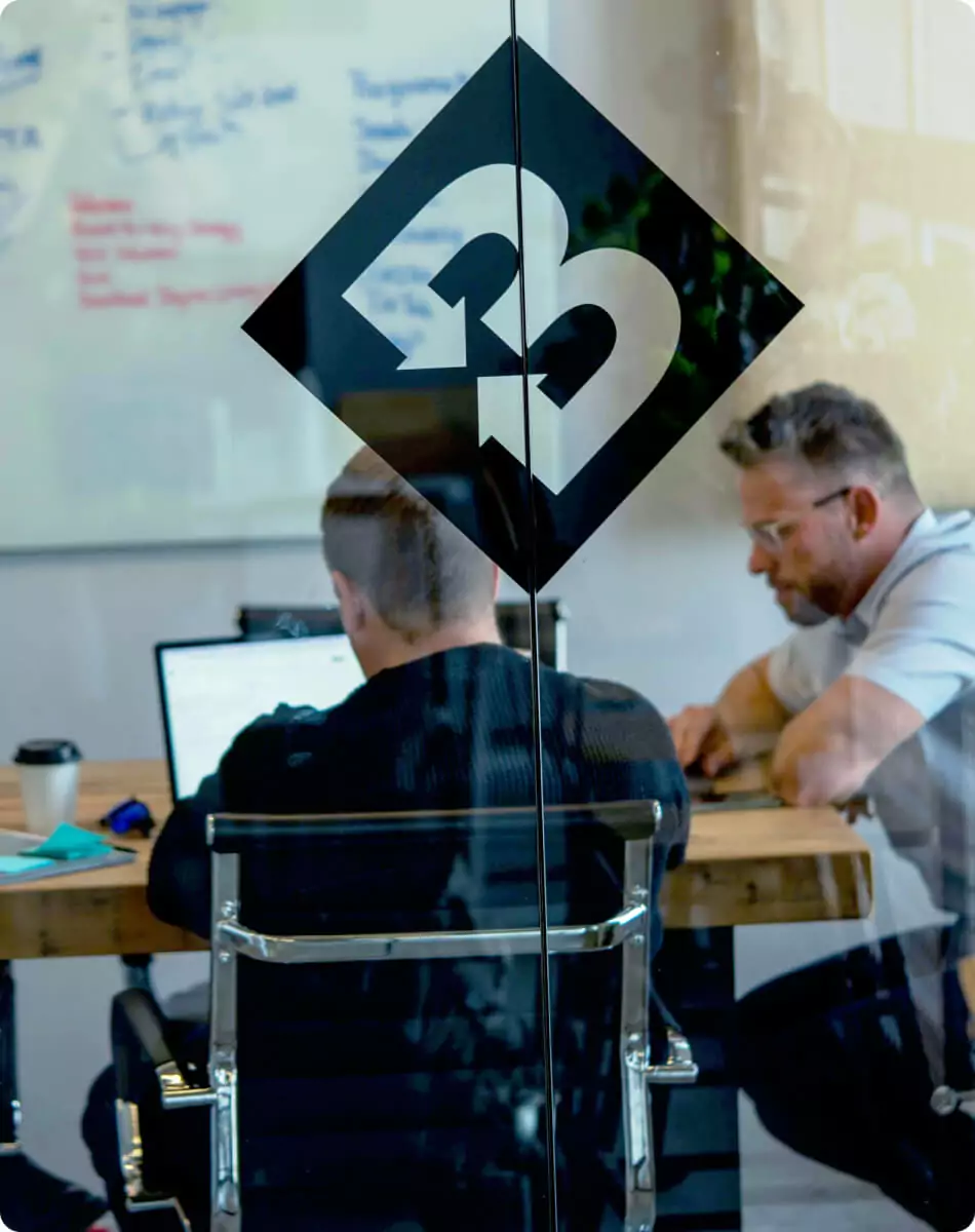 Team meeting in glass conference room at Blennd office