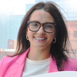 Professional headshot of woman smiling with glasses