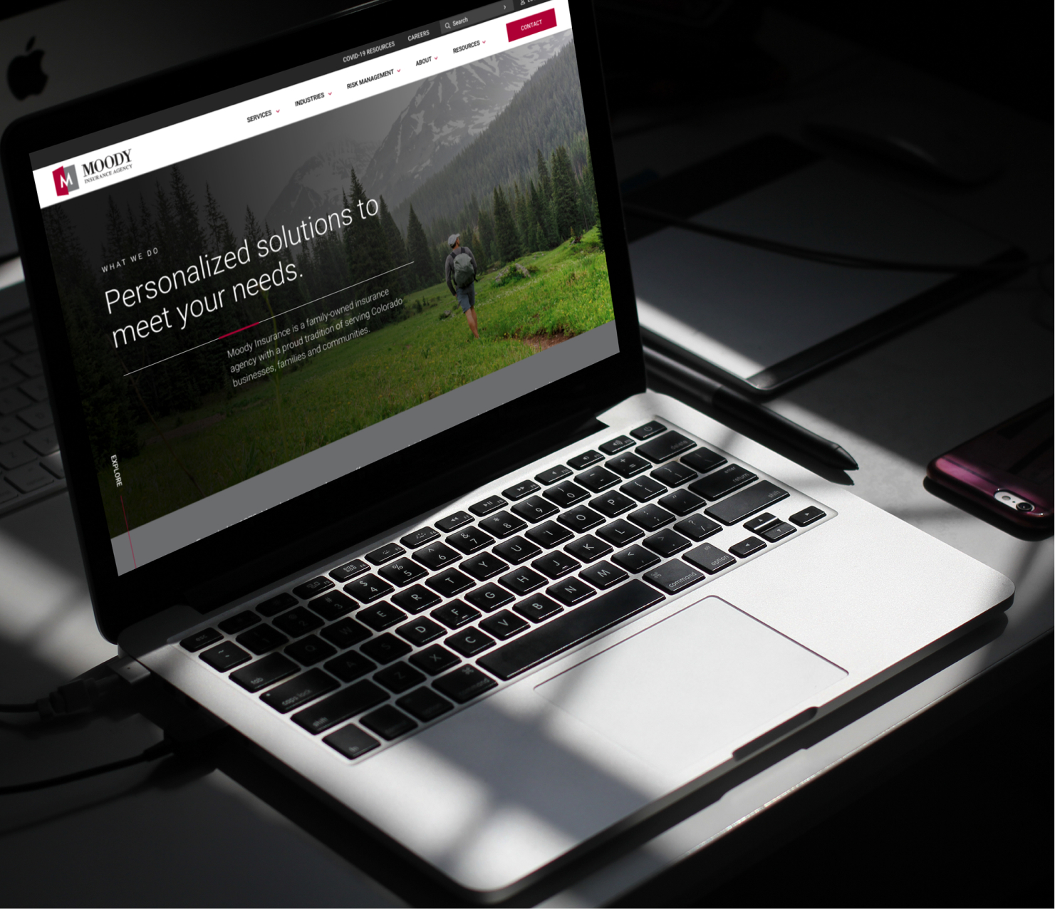 Laptop displaying website homepage in workspace