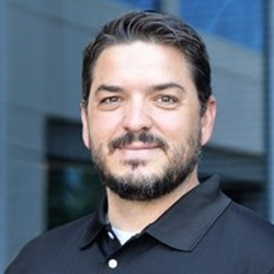 Professional headshot of male team member with beard