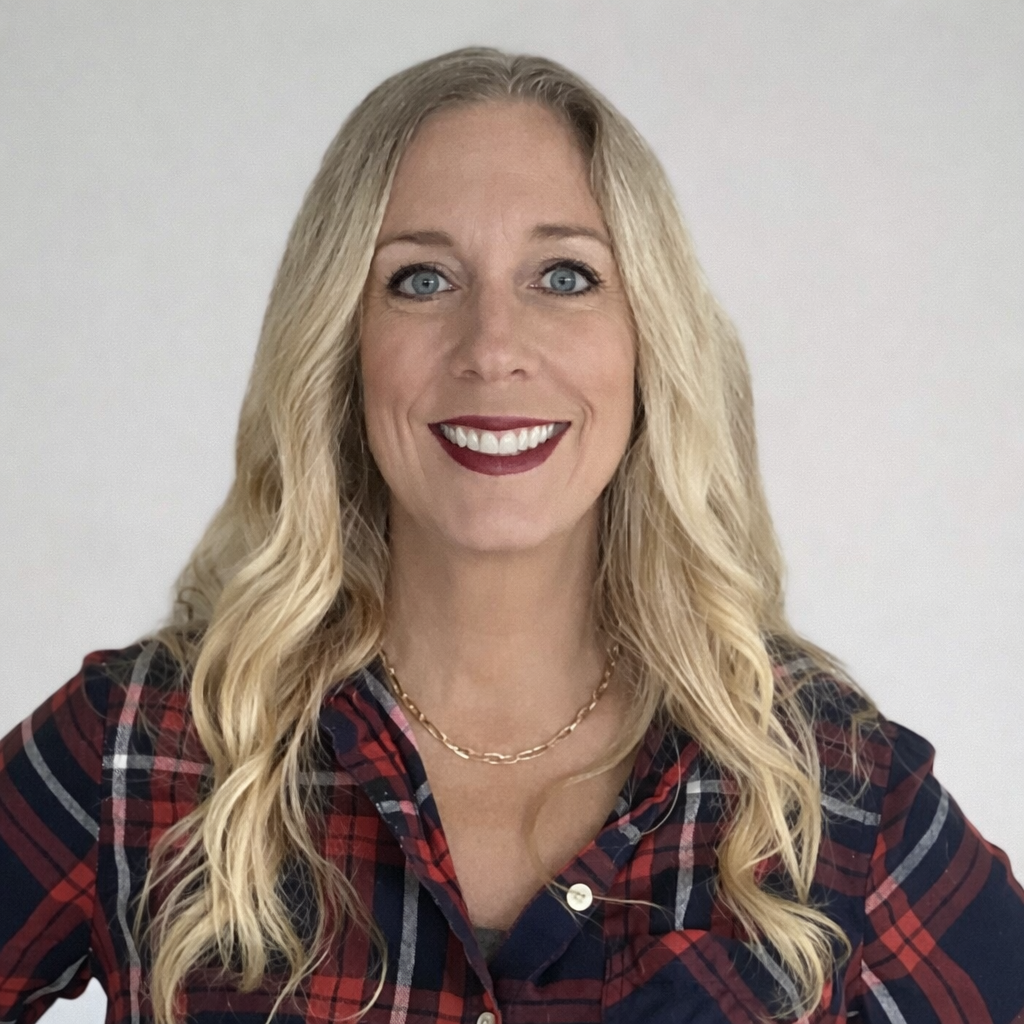 Professional headshot of female team member in plaid shirt