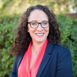 Professional headshot of woman smiling outdoors